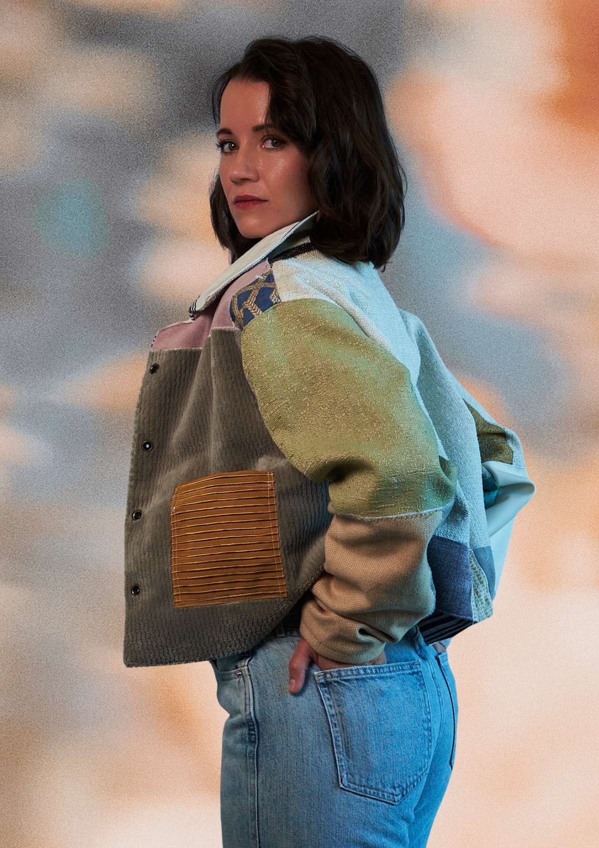Person wearing a patchwork jacket upcycled from upholstery swatches with a blurred background