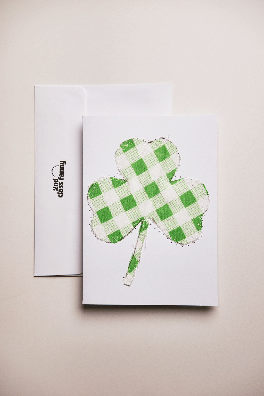 Card with a green checkered four-leaf clover design. upcycled from a bed sheet, on a beige background.