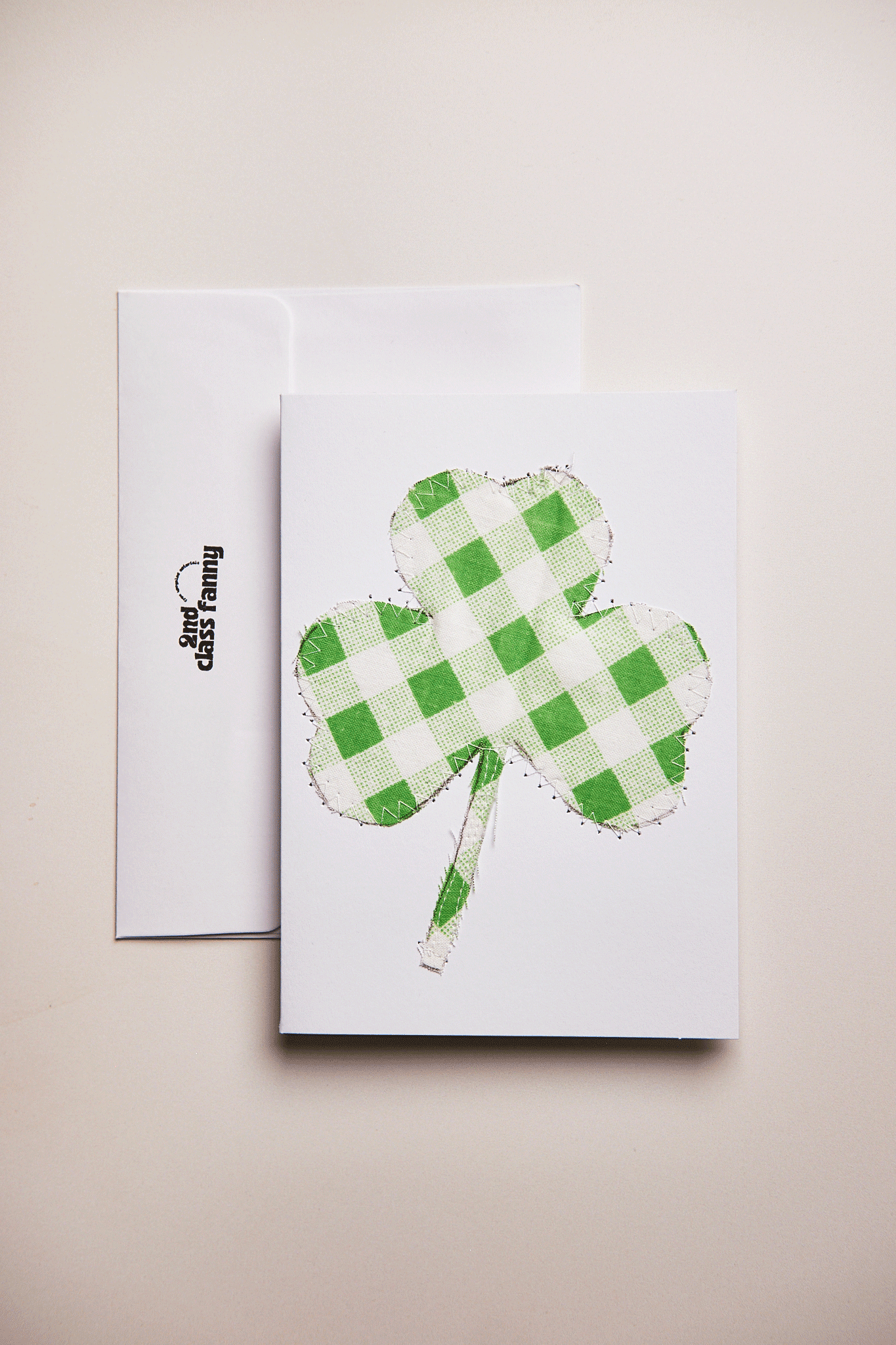 Card with a green checkered four-leaf clover design. upcycled from a bed sheet, on a beige background.