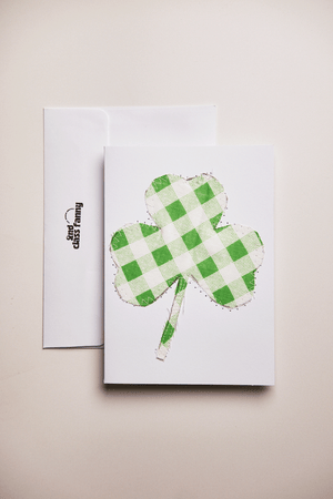 Card with a green checkered four-leaf clover design. upcycled from a bed sheet, on a beige background.