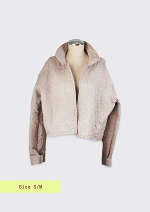 Beige jacket upcycled from comforter on a mannequin against a light gray background