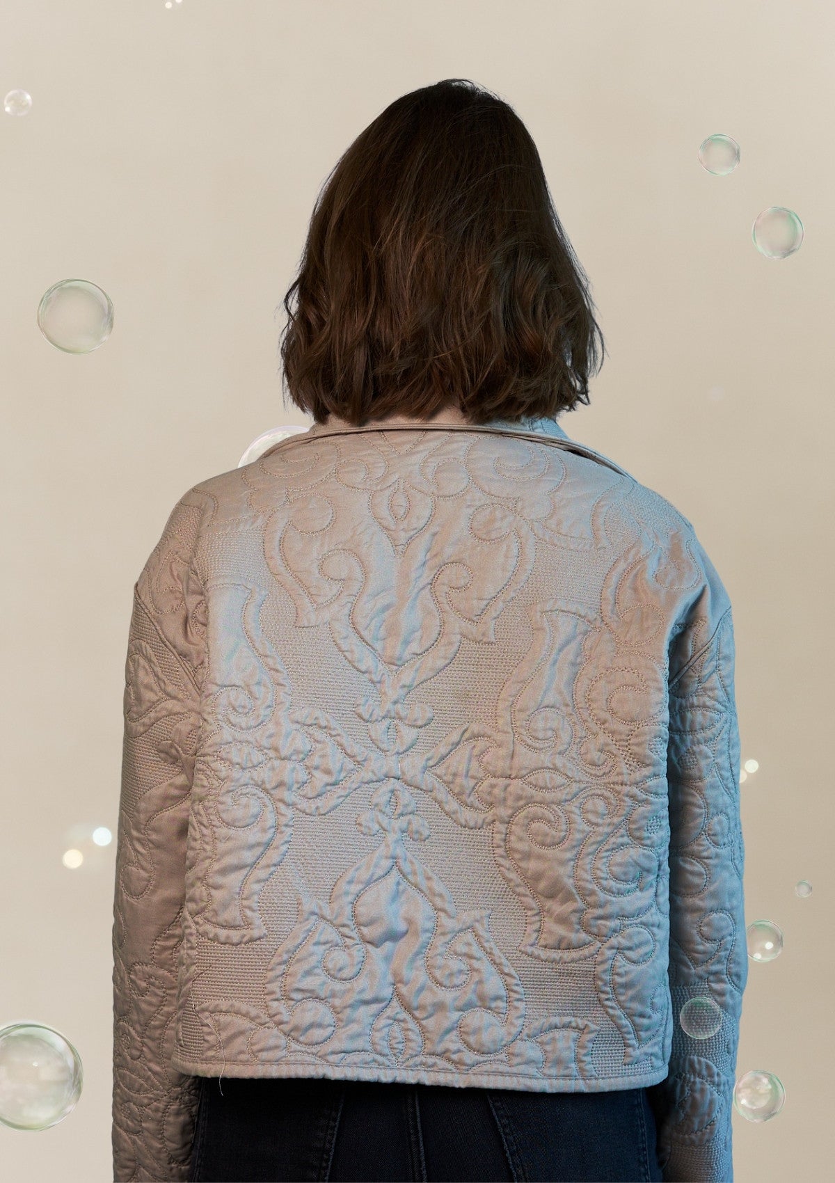 Person wearing a textured jacket upcycled from a comforter with a neutral background