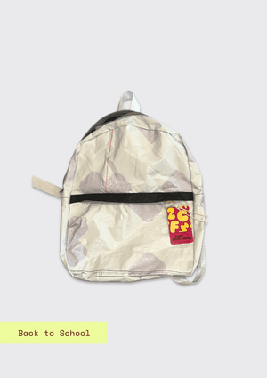 Backpack upcycled from a billboard vinyl  with a visible brand logo on a light gray background