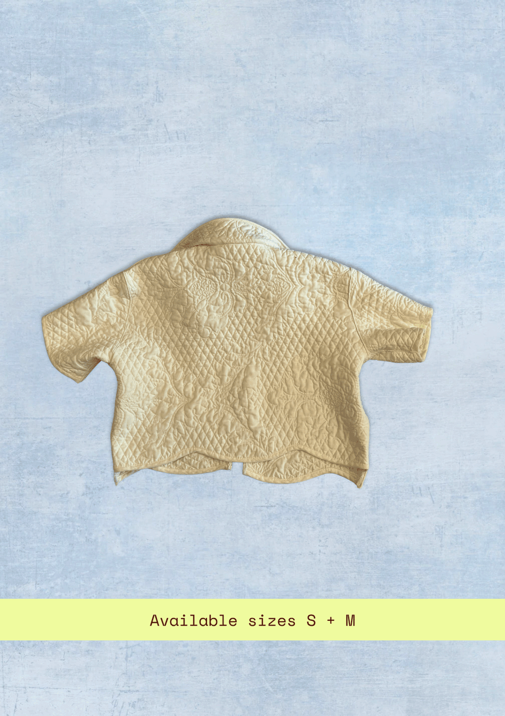 White textured jacket upcycled from a quilt on a light blue background with size information at the bottom.