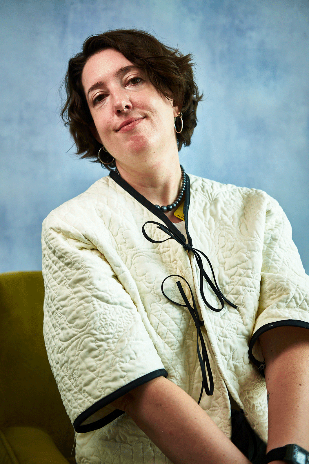 Person wearing a white quilted jacket upcycled from a quilt with a blue background