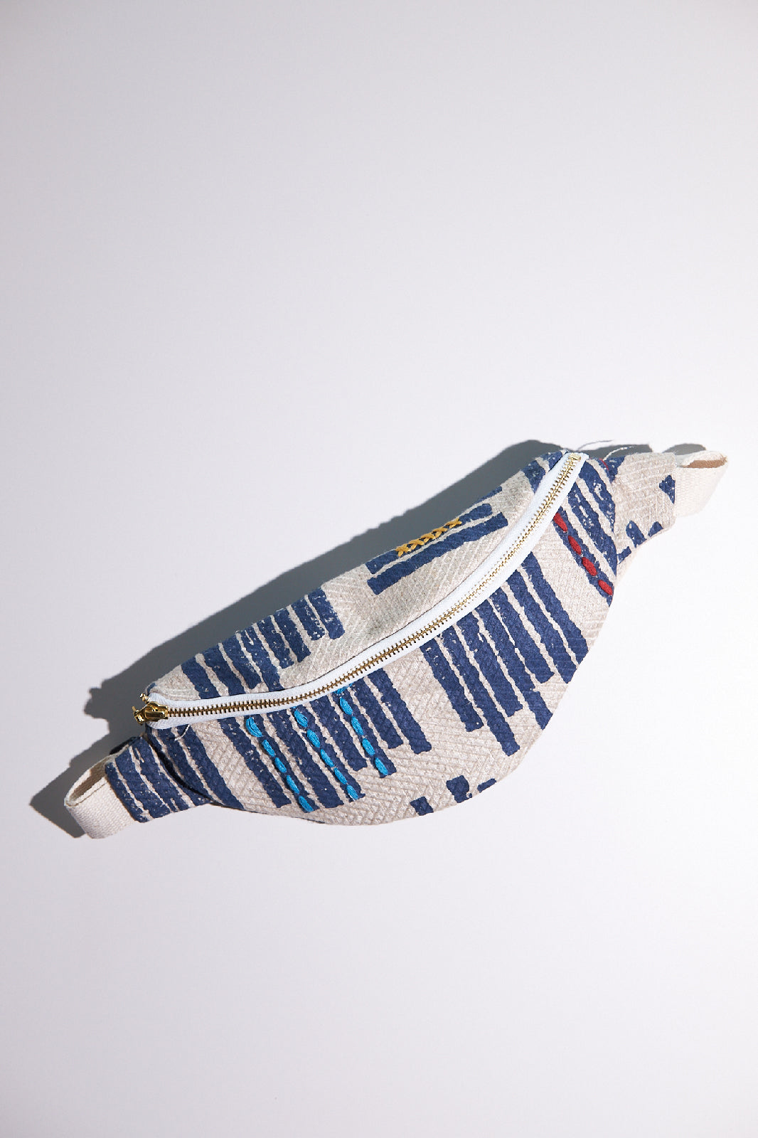 Fanny pack with blue and white pattern on a light gray background