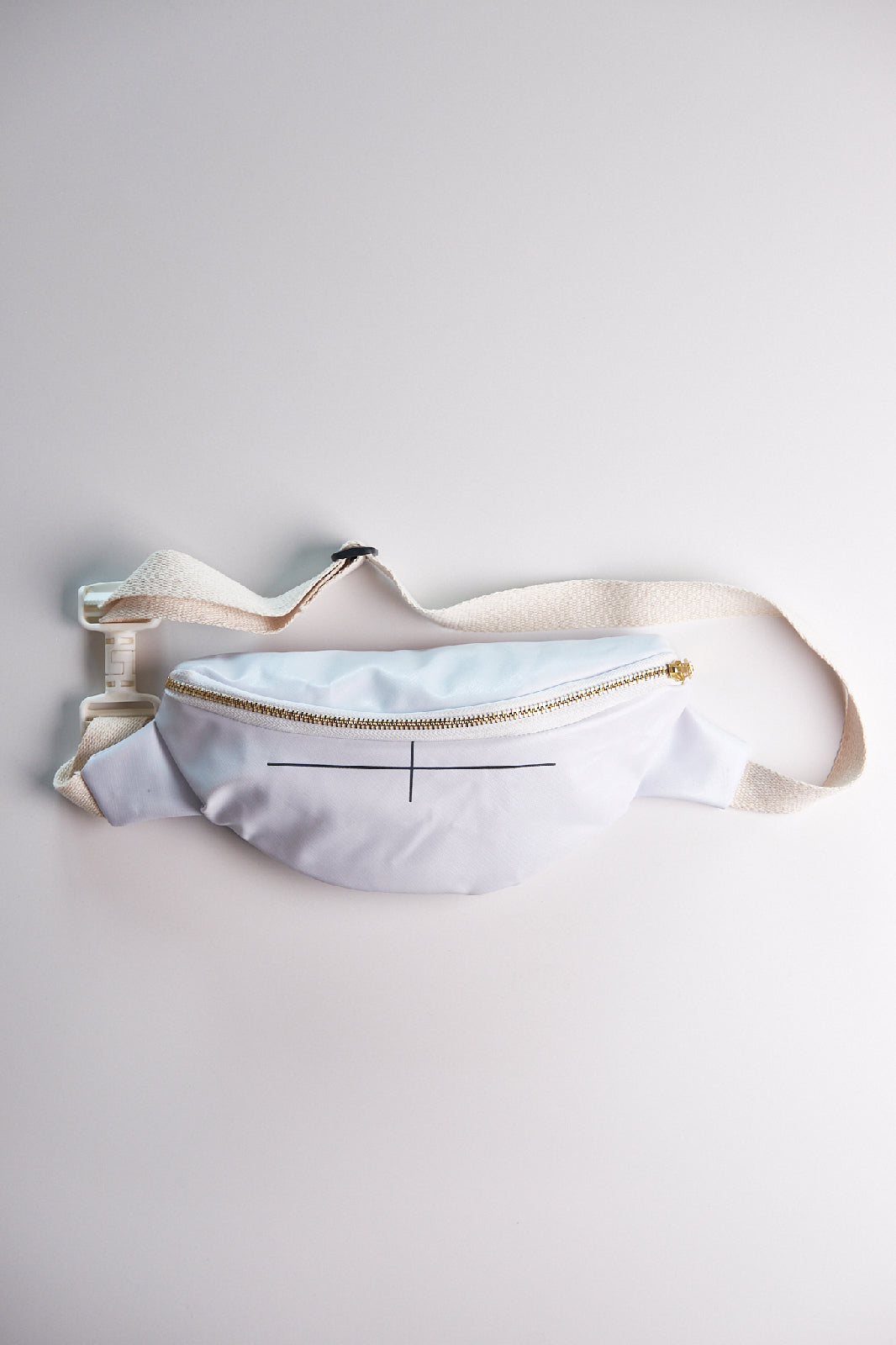 White waist bag with gold zipper on a light gray background