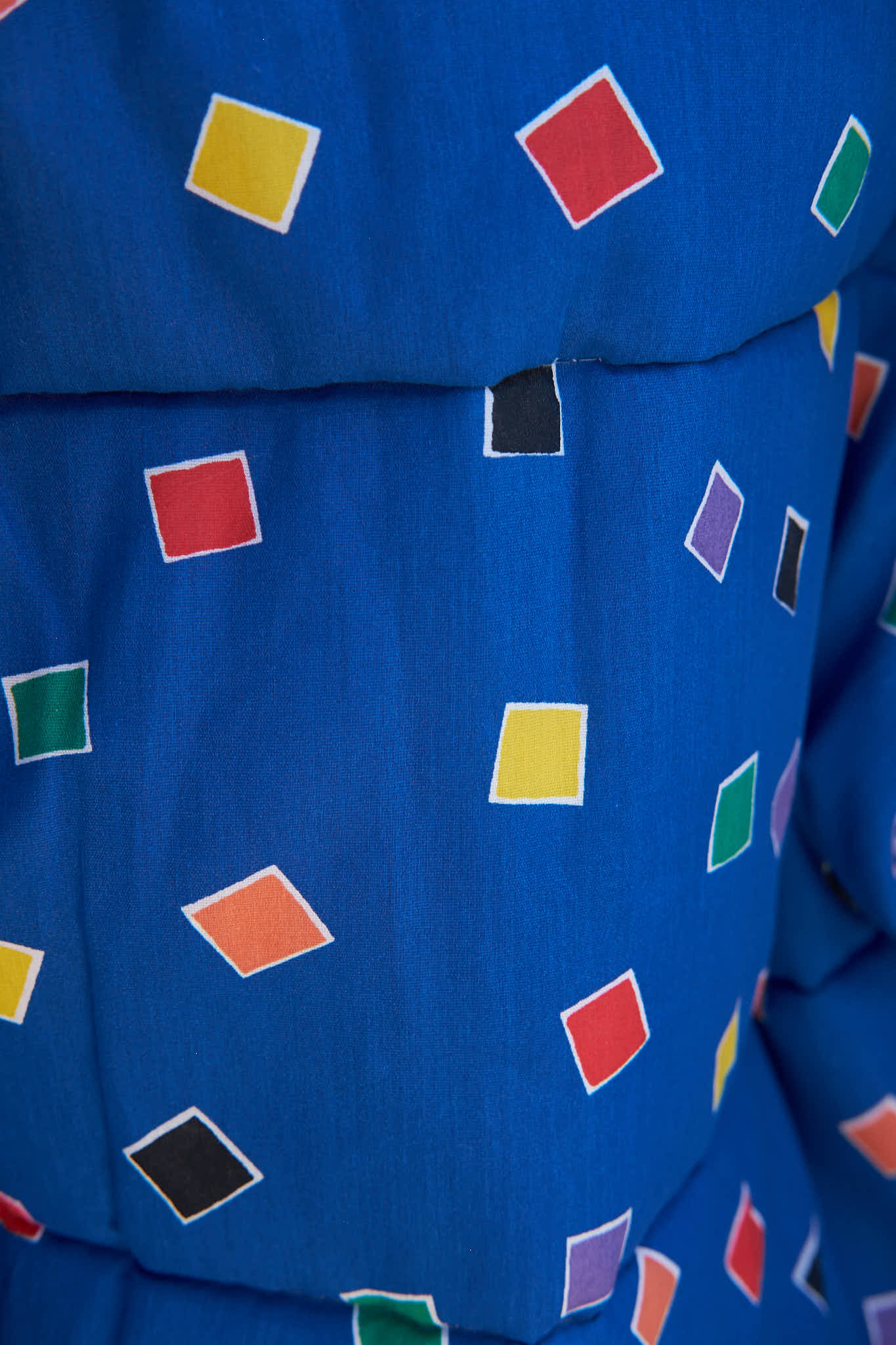 Close-up of a blue fabric with colorful diamond patterns made from upcycled comforter