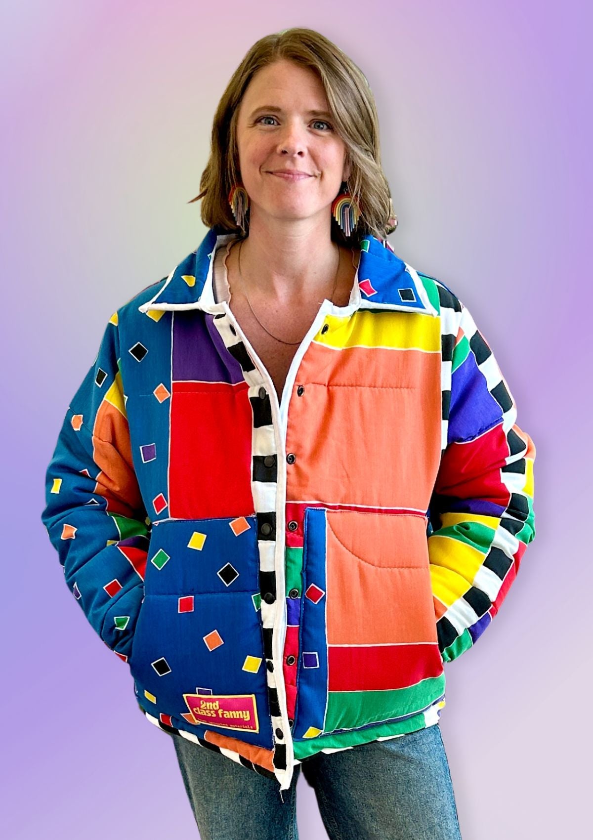 Person wearing a colorful quilted jacket with an 80s inspired patterned upcycled from a comforter