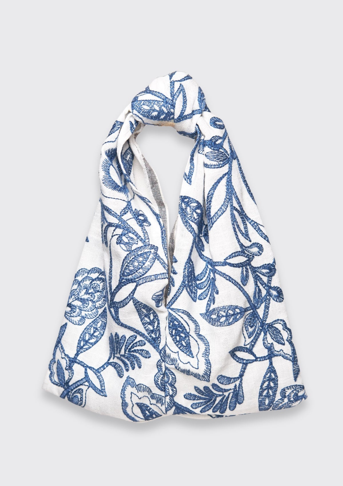 Blue floral patterned knot bag upcycled form designer deadstock fabric on a white background