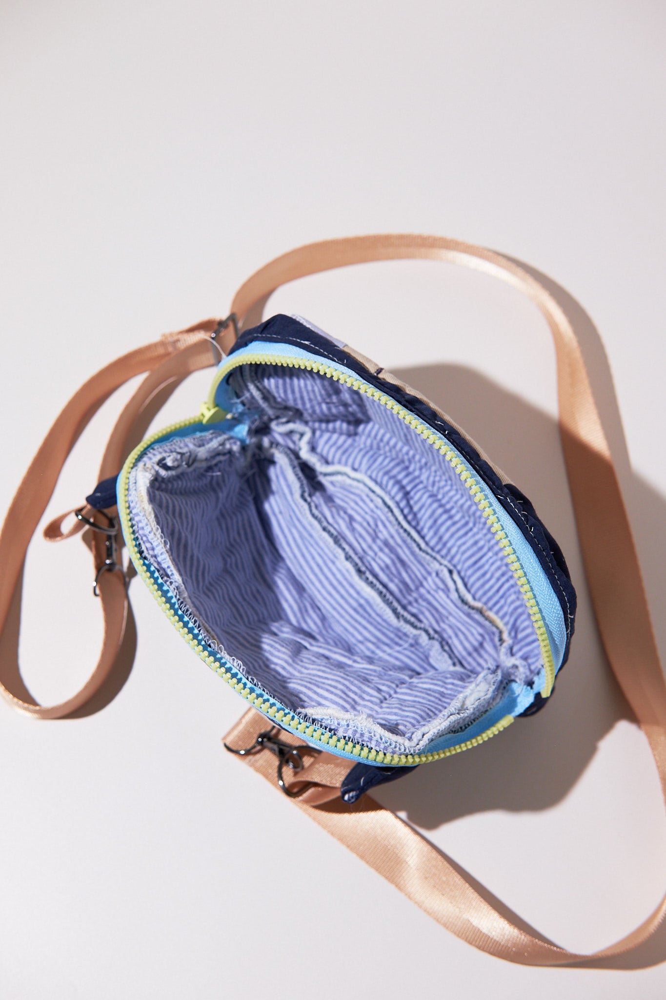 Open zipper crossbody / fanny bag upcycled from quilt with a beige strap on a white background