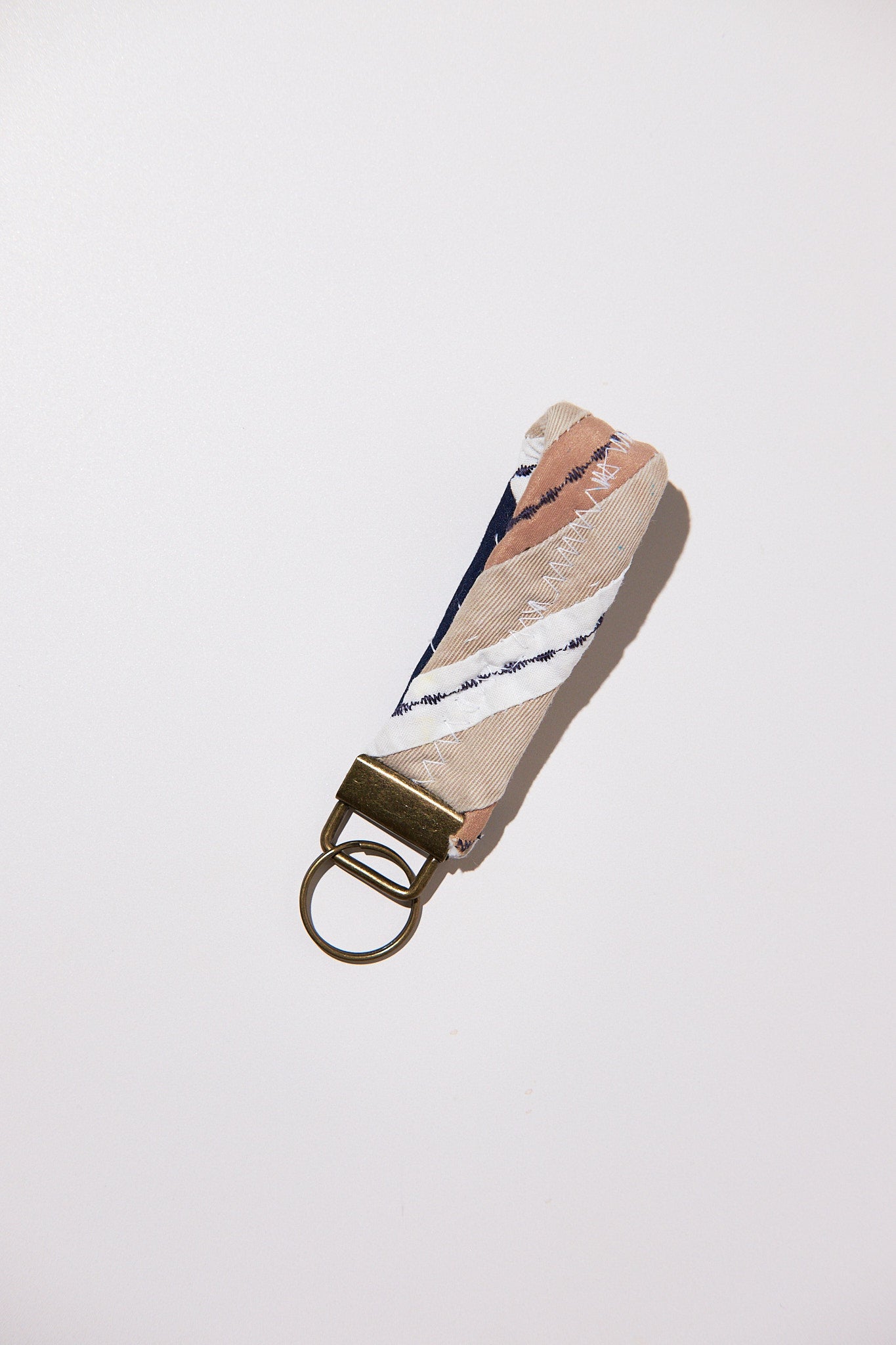 Keychain with patterned strap and gold clasp upcycled from comforter on a white background