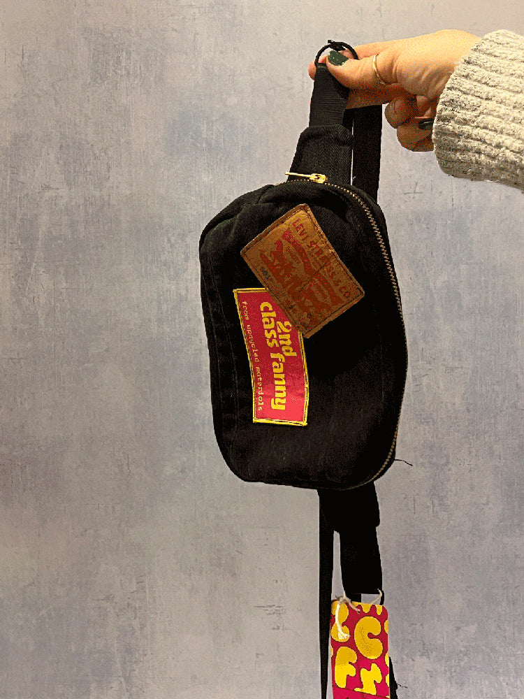 Black bag with colorful patches on a gray background