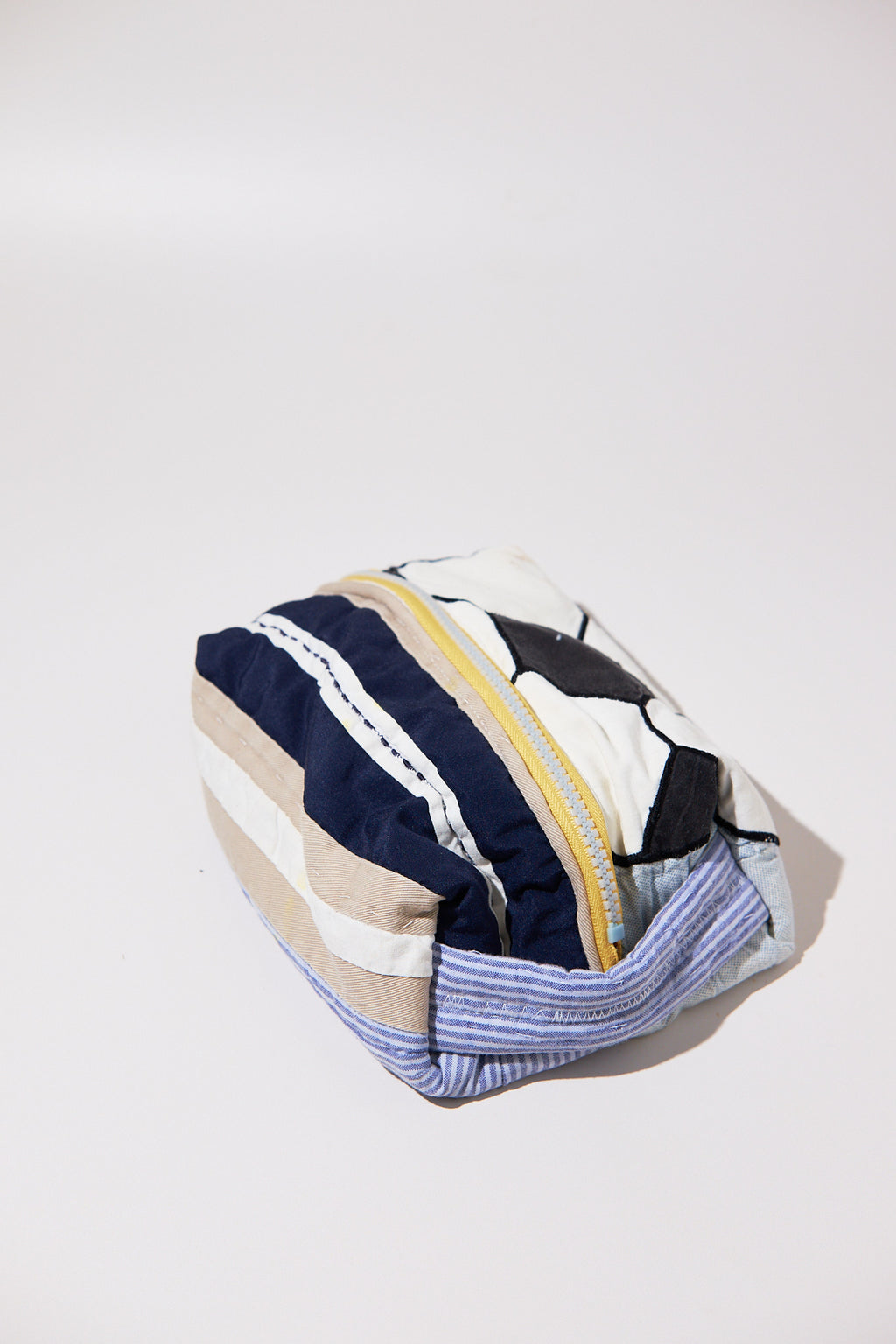 Striped pouch with a zipper and soccer ball upcycled from quilt on a white background