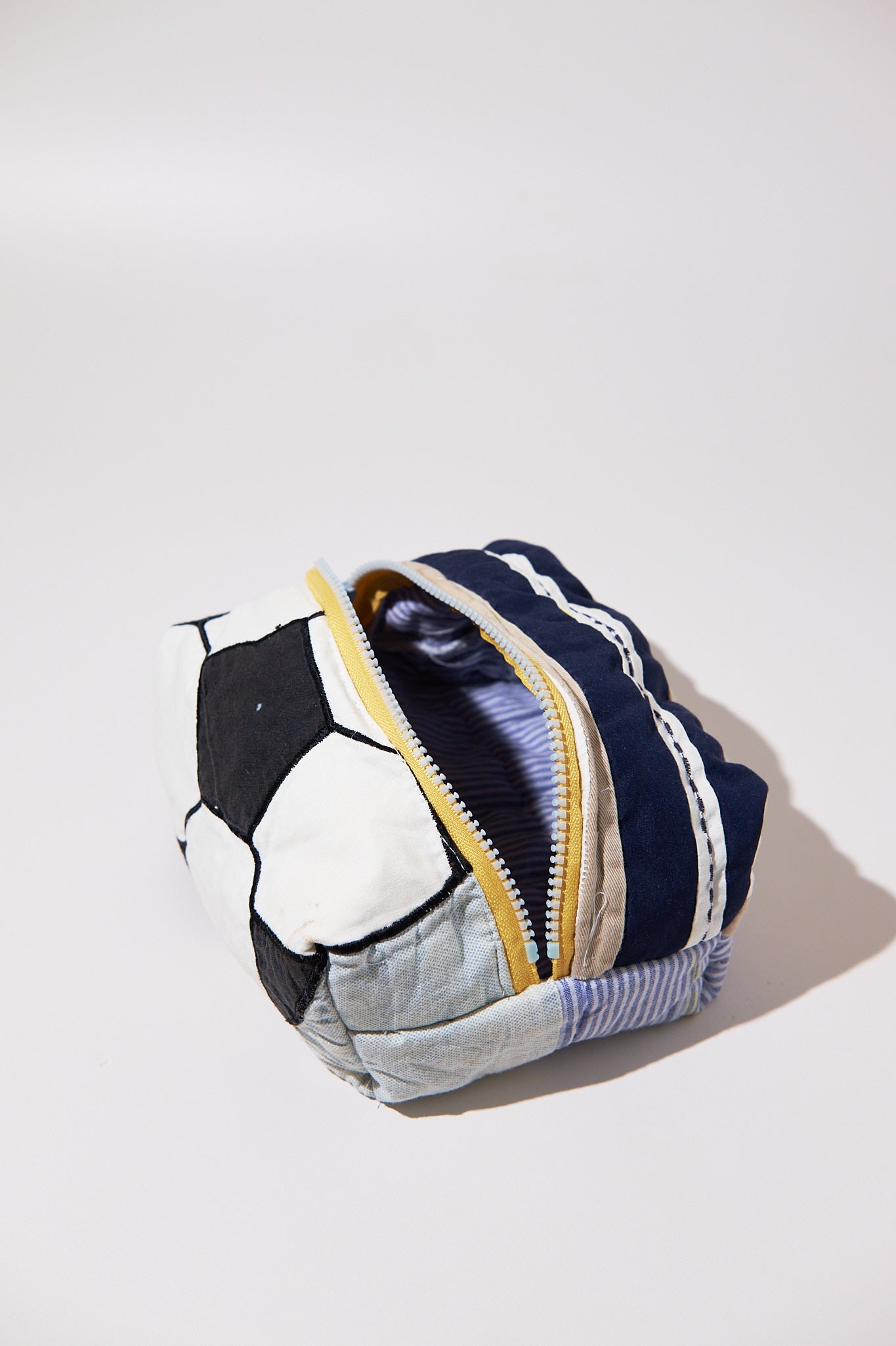 Multicolored fabric dob kit with a zipper upcycled quilt on a white background