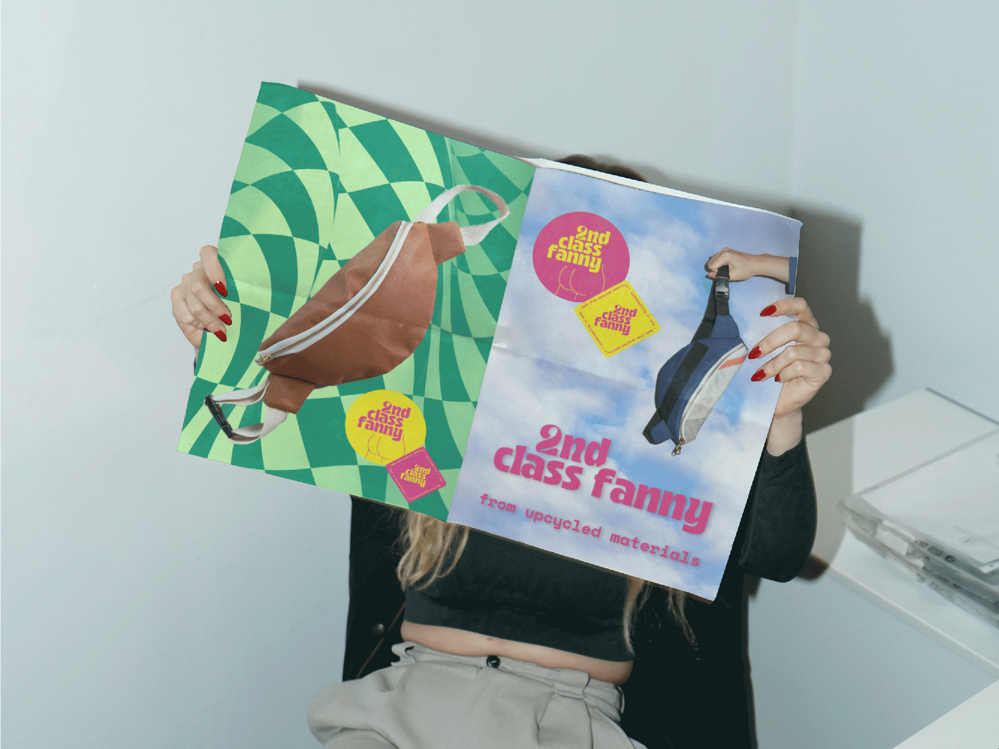 Person holding two books with colorful covers against a light blue wall.