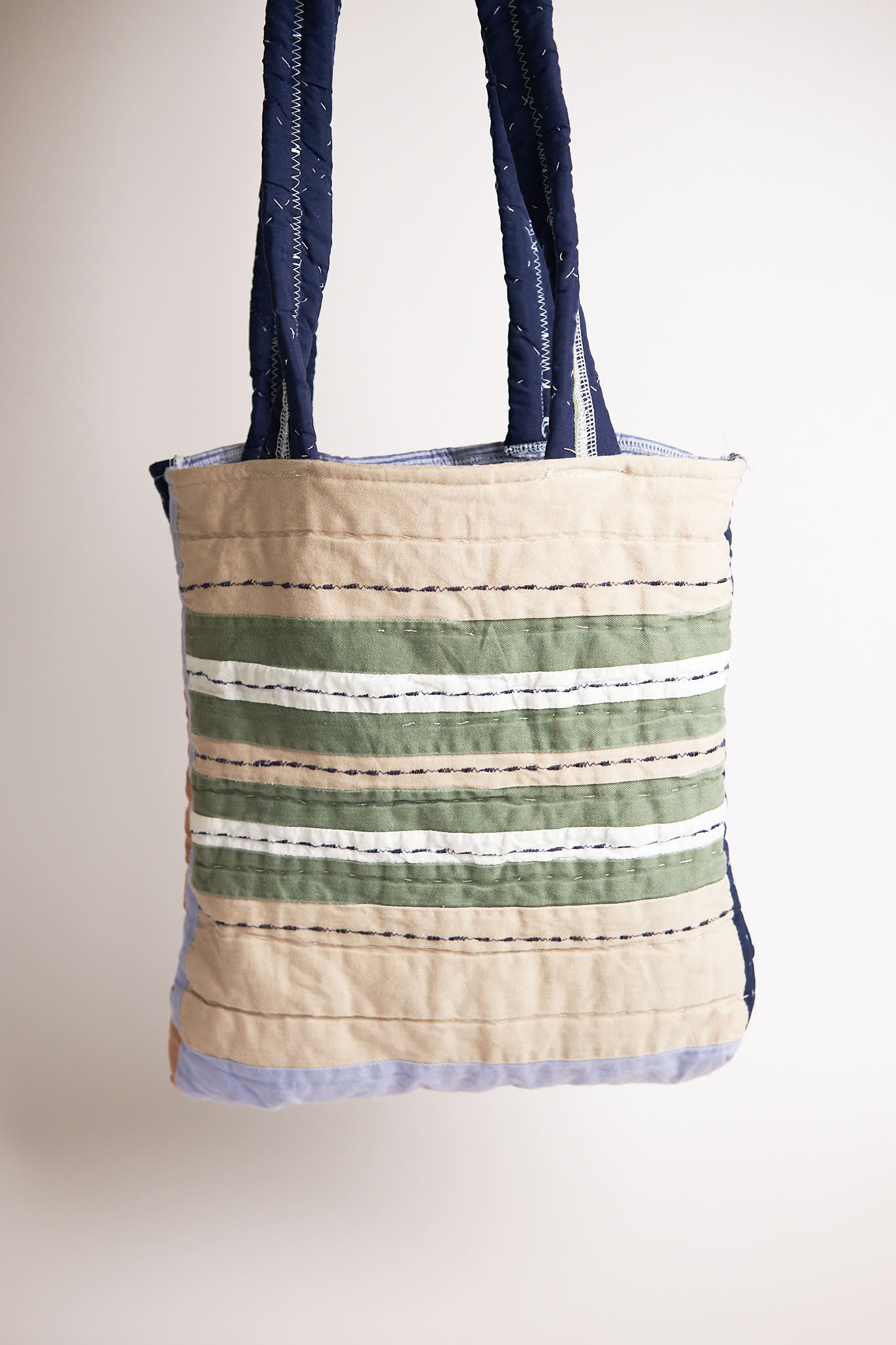 Tote bag with striped pattern upcycled from a quilt on a plain background