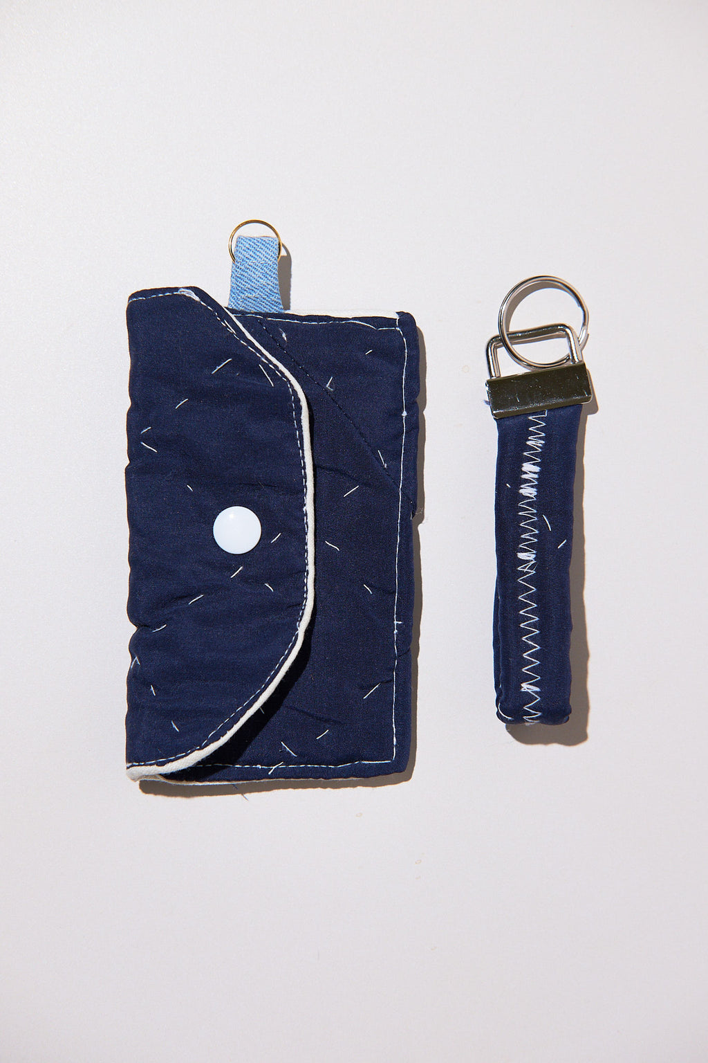 Navy blue wallet with keychain upcycled from comforter on a white background