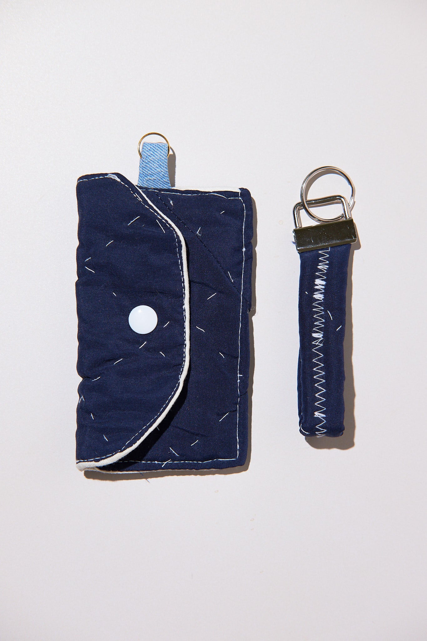 Navy blue wallet with keychain upcycled from comforter on a white background