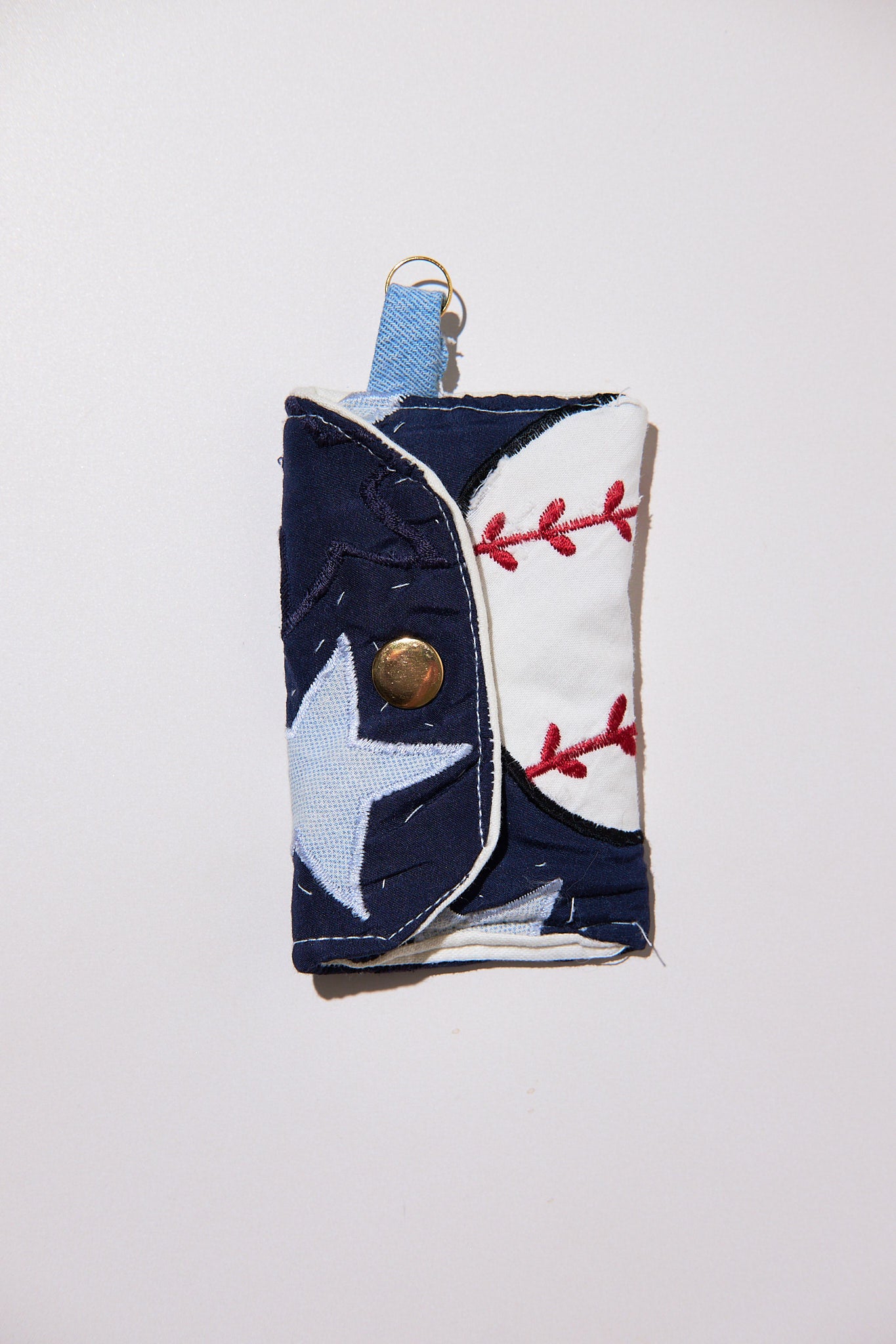 Fabric keychain with star and baseball design upcyceld from comforter on a white background