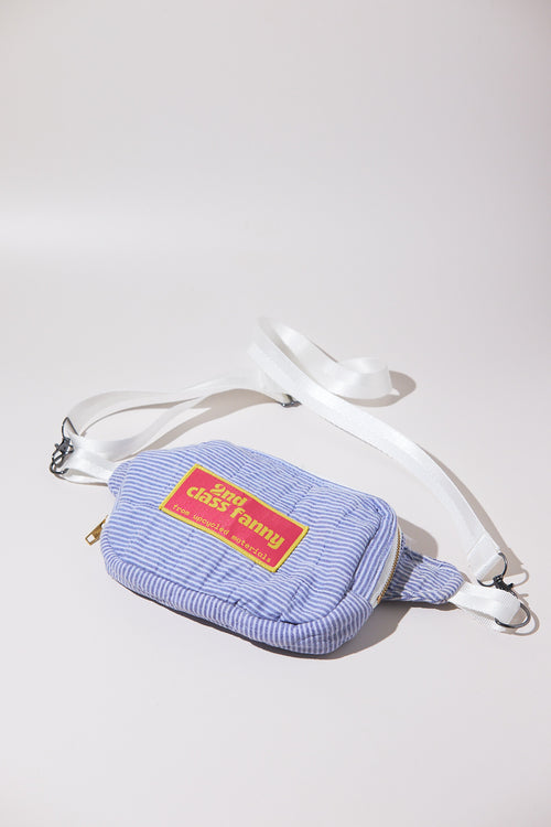 Crossbody bag / Fanny pack in blue striped seersucker pattern with a red label reads 2nd Class Fanny on a white background