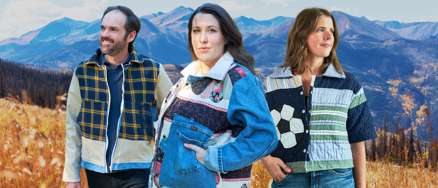 Three people standing outdoors wearing jackets made from upcycled materials  with mountains in the background